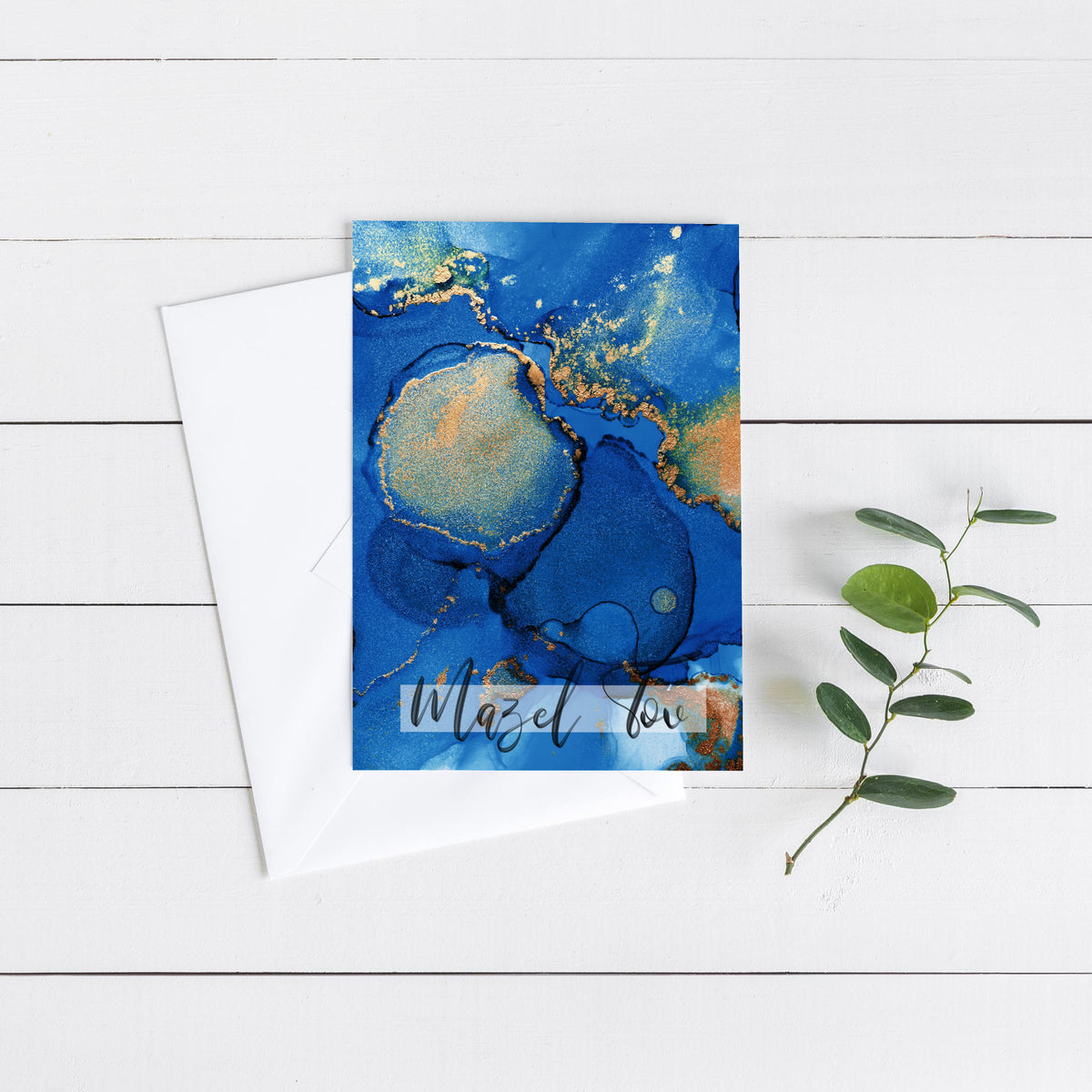 Greeting cards with a fluid abstract pattern in royal and cobalt blue, gold patches, and "Mazel tov" script.