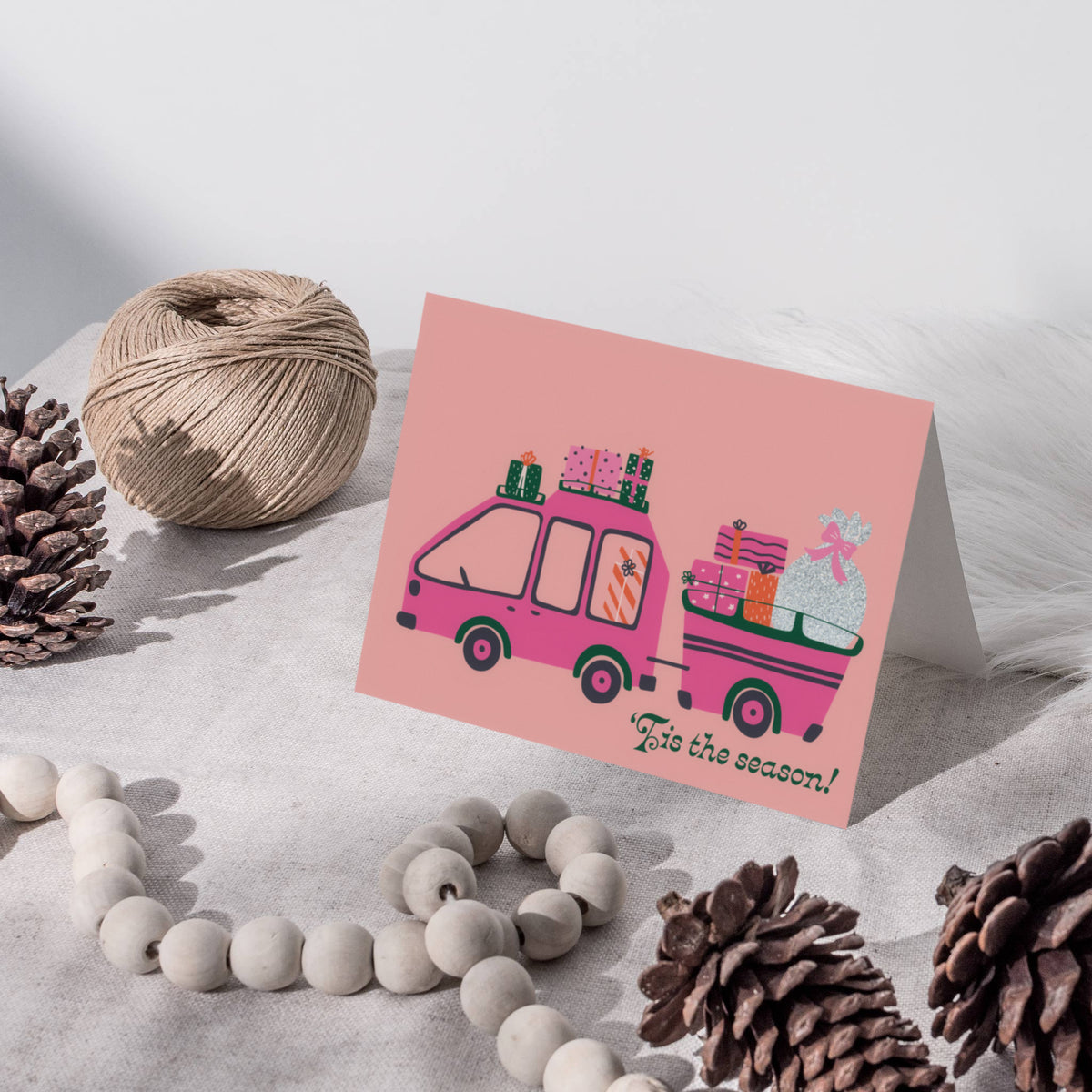 Four-design Christmas card set with flat illustrated cars and trucks hauling trees and presents.