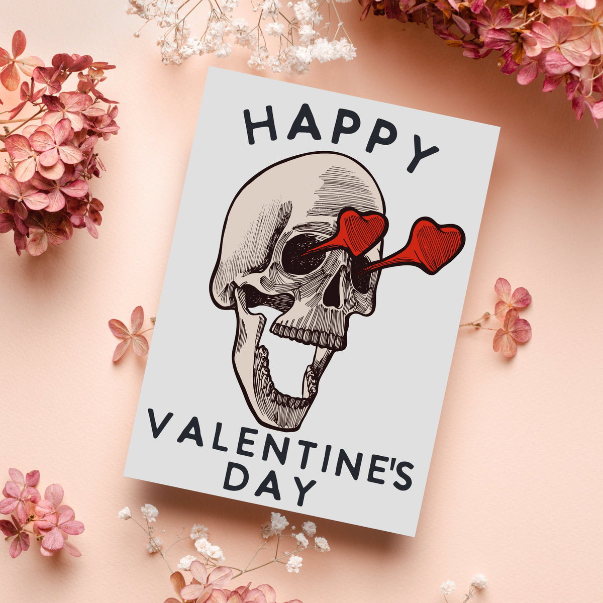 Valentine card featuring a cross-hatched skull facing three-quarters left, heart glasses, cream and dark brown linework on wh