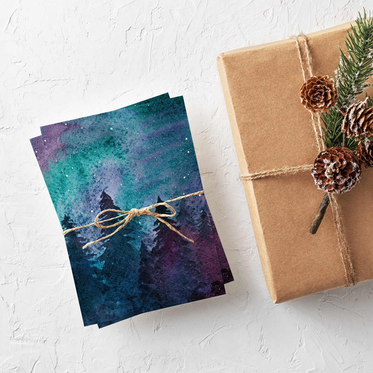 Folded holiday card, single design repeated 24 times, featuring a teal-to-magenta sky and black tree silhouettes.