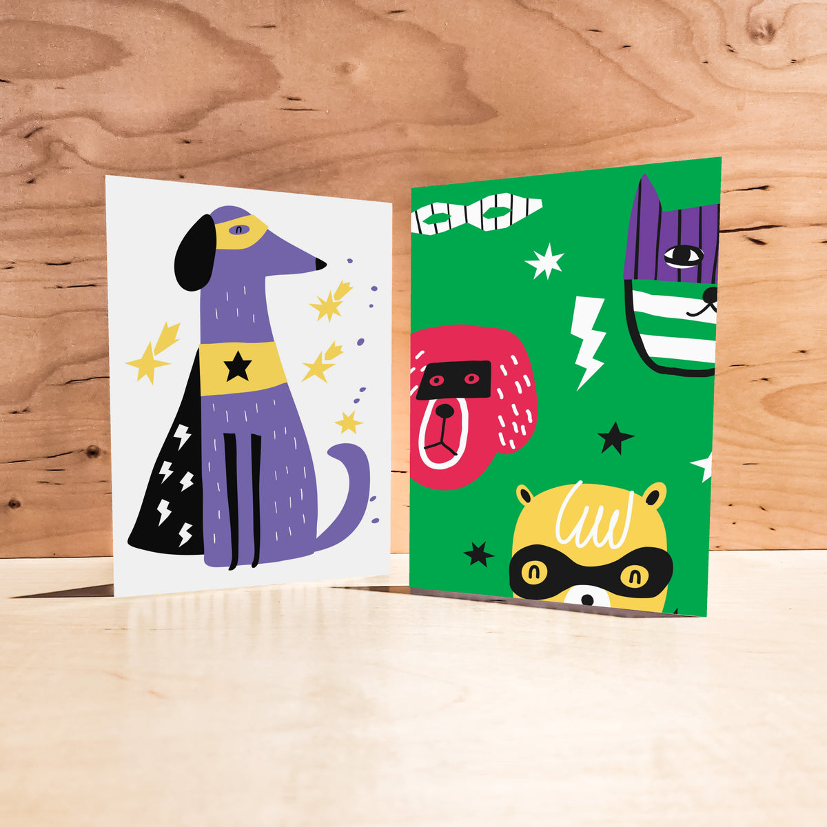 Set of 24 cards in two repeating designs showing cartoon animals dressed as superheroes with bold graphic elements.