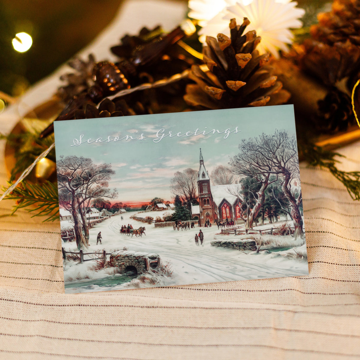 Christmas cards, one design, chromolithograph style, featuring a church spire, sunset sky, and snow-blue shadows.