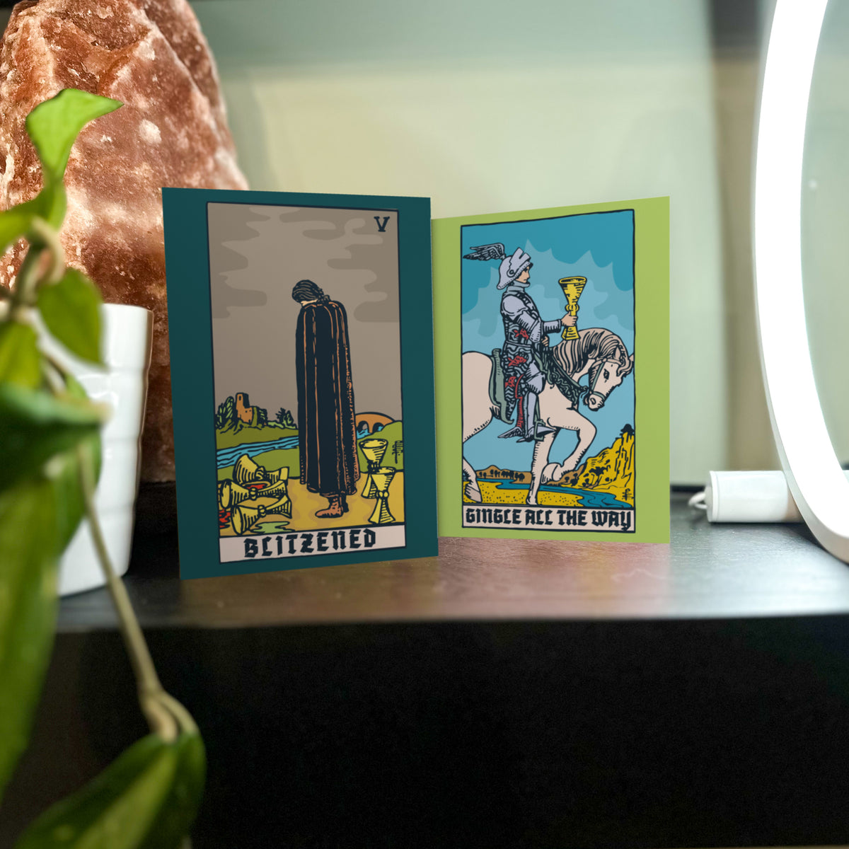 Six designs, four cards each, recreating classic tarot compositions with holiday phrases like "BLITZENED" and "WHAT A YEAR."