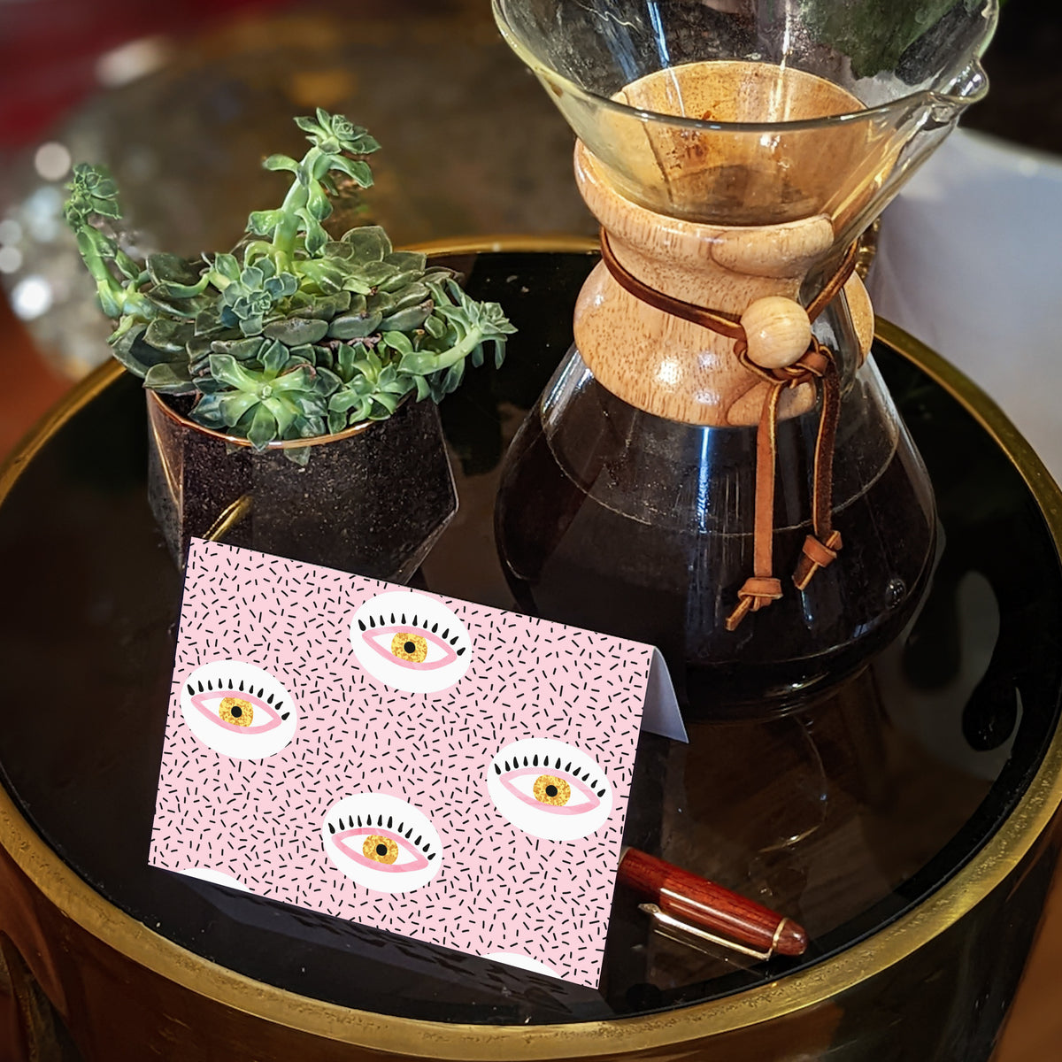 Two-design notecard set with bold, repeating illustrated eyes in a pink, yellow, and black color palette.