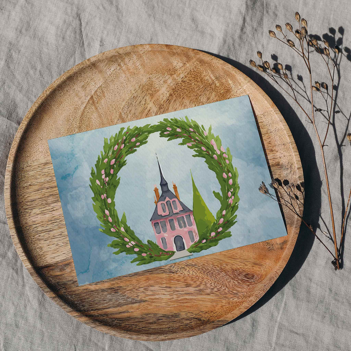 Holiday cards in two designs, each showing a pink spired mansion inside an open-top evergreen wreath.