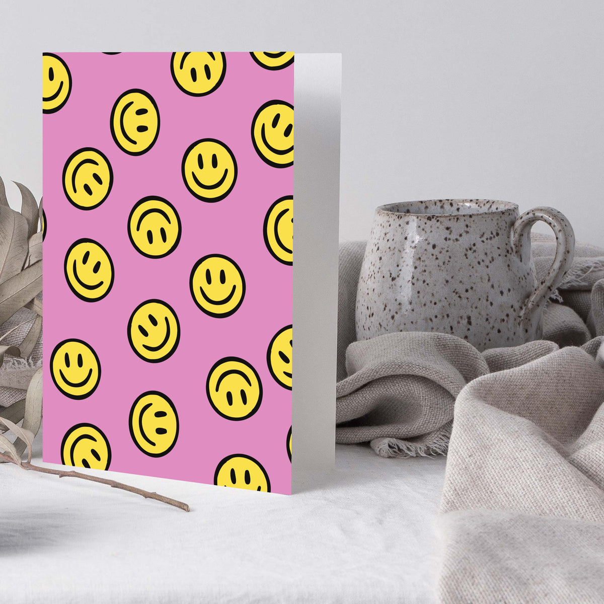 Set of notecards with black-outlined yellow smiley faces covering a pink background.