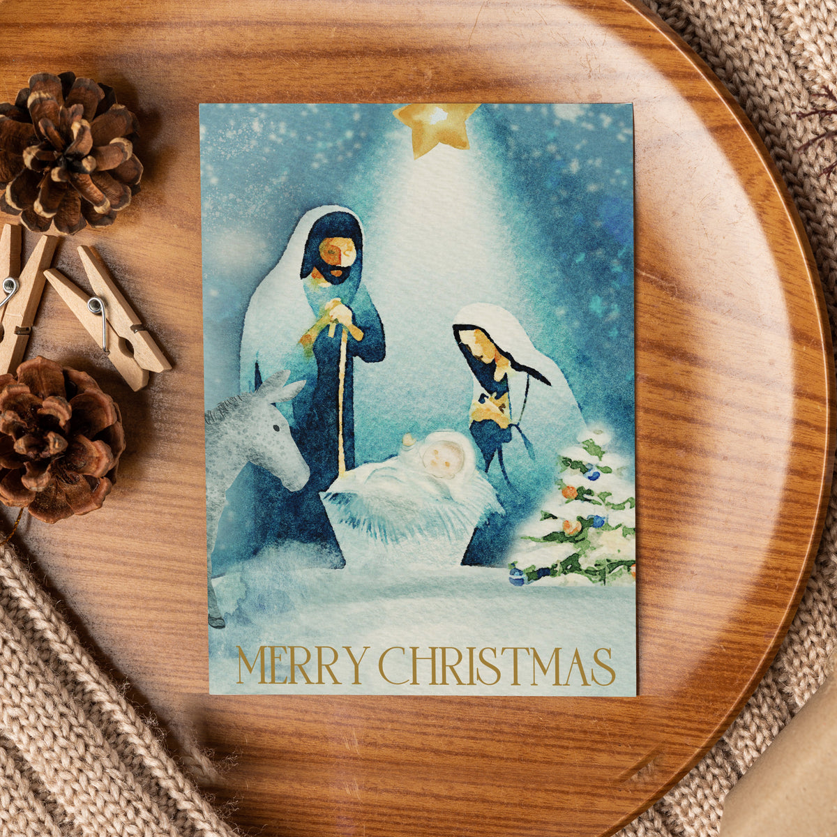 Single-design holiday card pack of 24 with evergreen tree, gold star, navy and gold figures on blue watercolor background.
