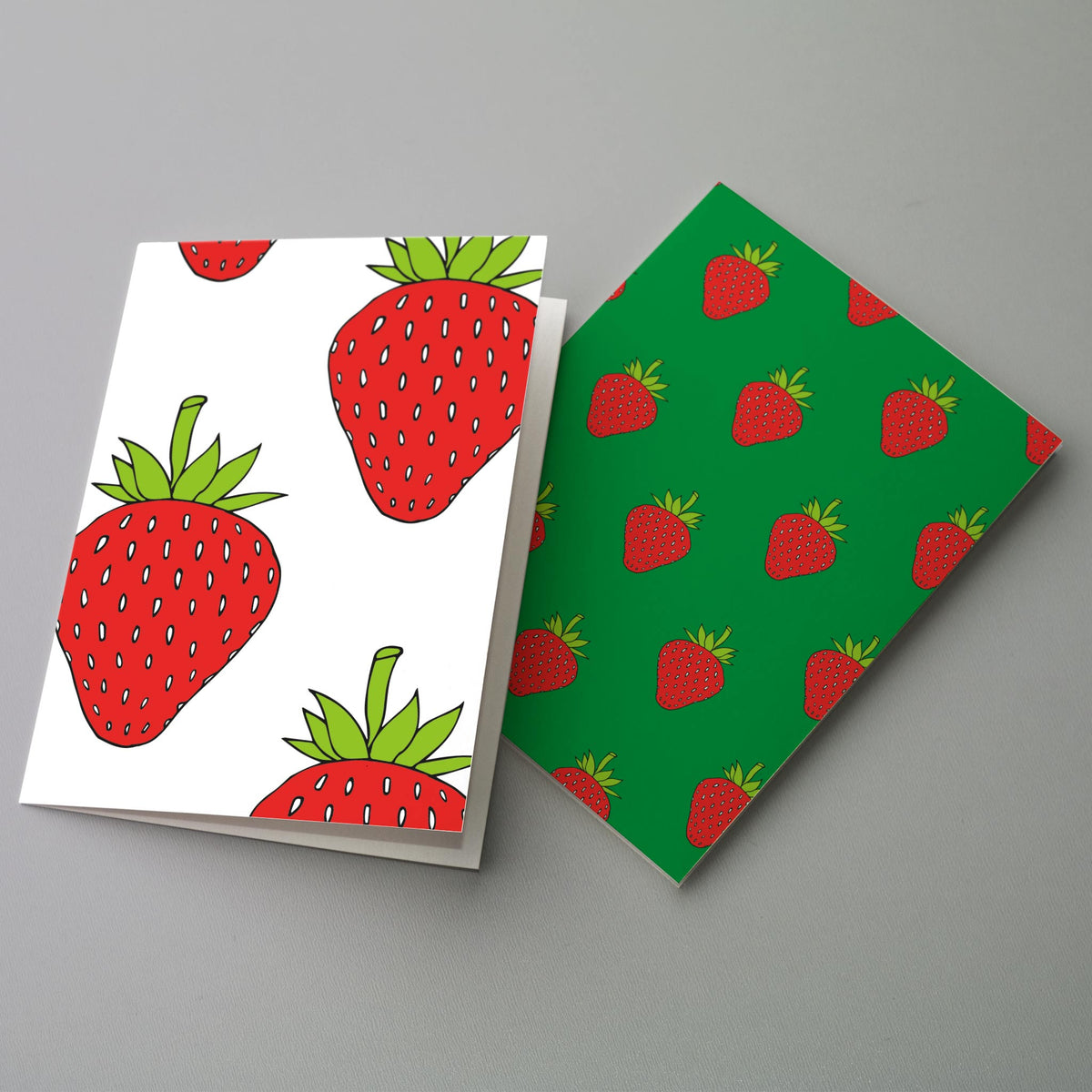 Colorful notecard set featuring outlined red strawberries with green tops.