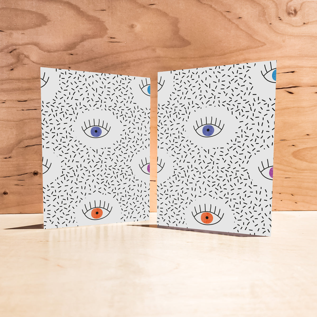 Set of 24 white cards featuring an all-over illustrated eye pattern in bold, multicolor linework.