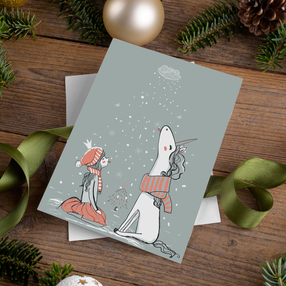 24-count card pack, one design, line art of a kneeling girl and unicorn with snow falling from an overhead cloud.