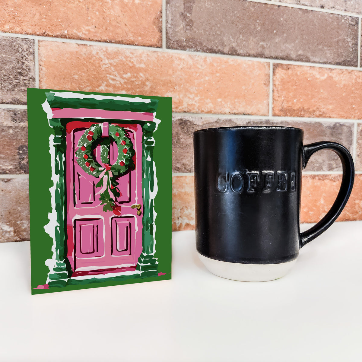 Christmas cards in four designs, each with a pink painted door, green wreath, and seasonal garland details.