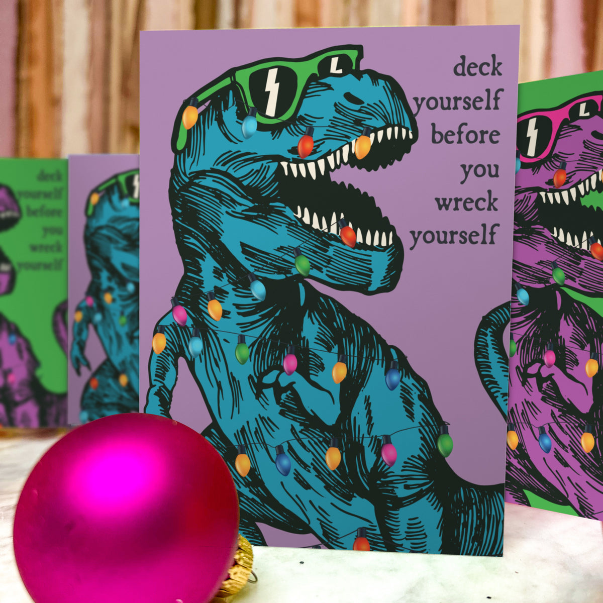Roaring T-rex with multicolor light strand looped around its body, shown on green and lavender cards.
