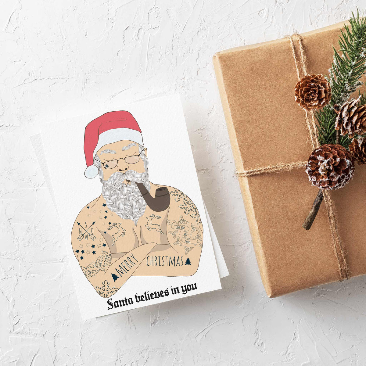 Holiday greeting cards depicting a tattooed Santa illustration on a white background with blackletter text below.