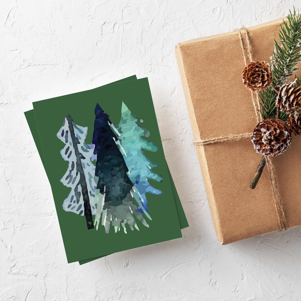 Christmas cards in 12 designs showing single, paired, and clustered abstract tree illustrations.