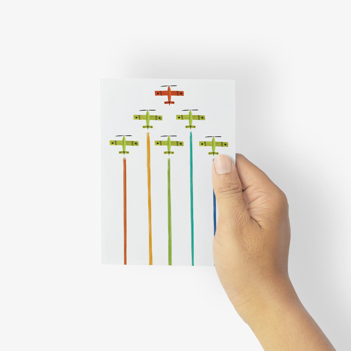 Cards printed with a graphic V-formation of propeller aircraft trailing vertical rainbow-colored smoke.