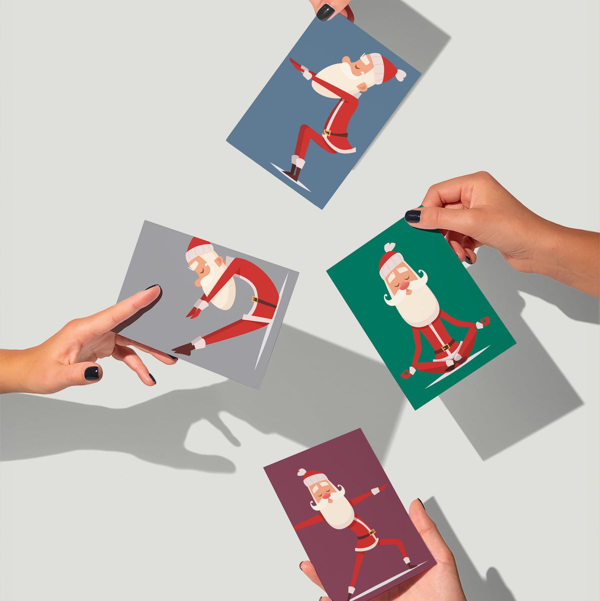 Christmas cards with cartoon Santa in poses including reclined twist, standing lunge, and wide-legged warrior.