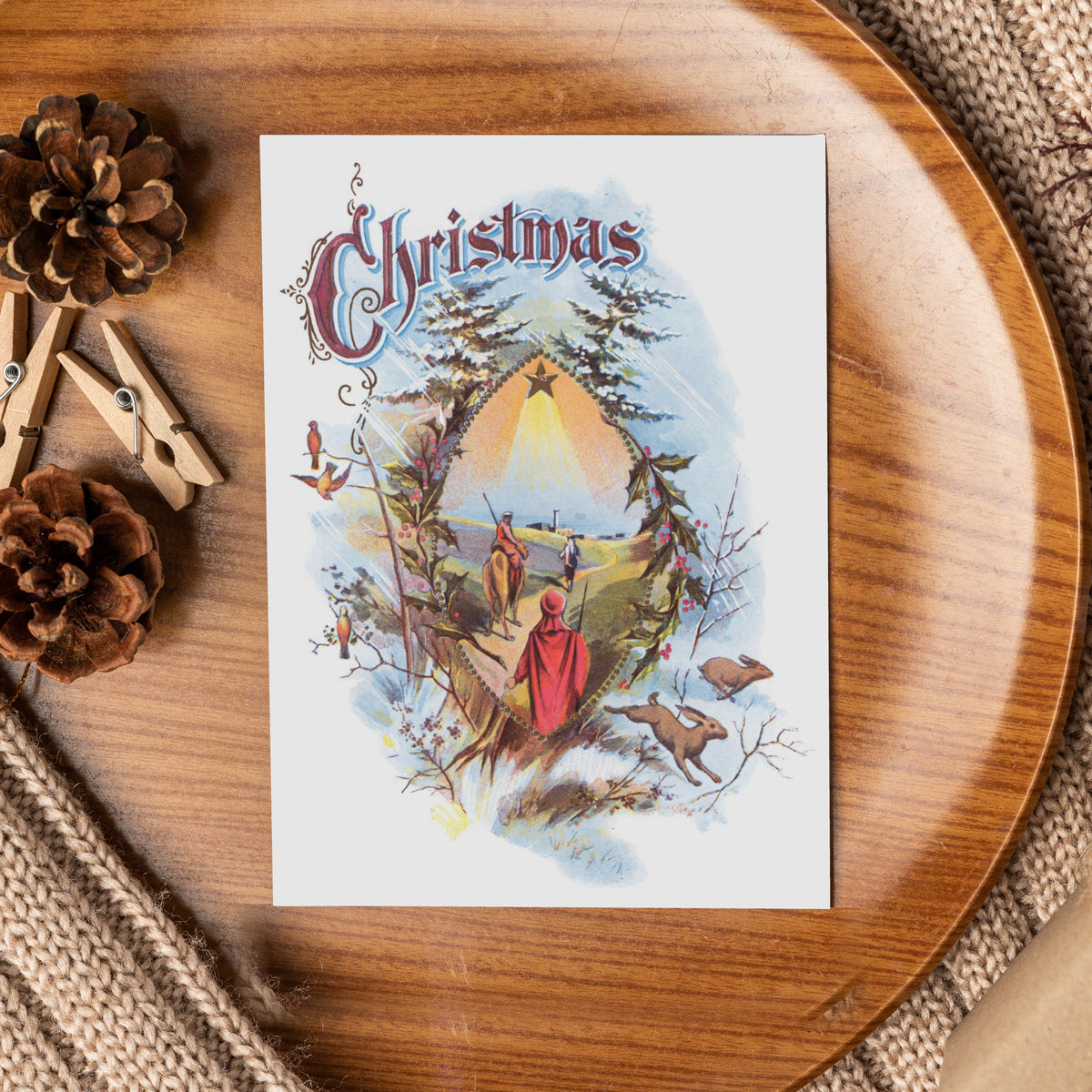 Pack of 24 matching nativity cards, portrait orientation, Victorian display lettering, holly sprigs, and a starlit Magi scene