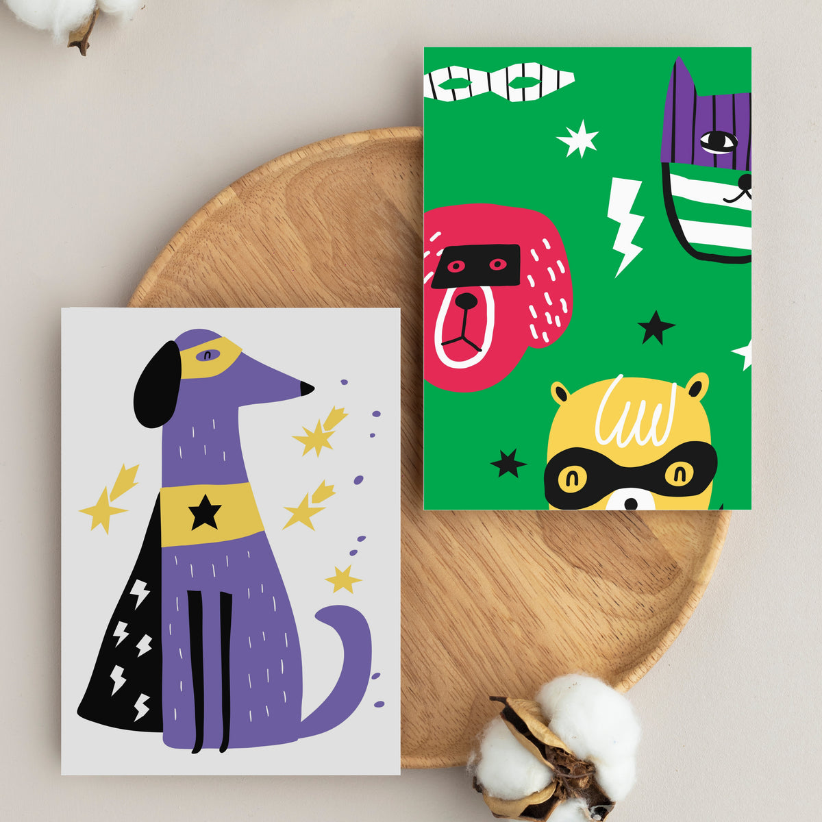 Full-bleed animal illustrations with superhero masks, capes, stars, and lightning bolt accents across two card designs.