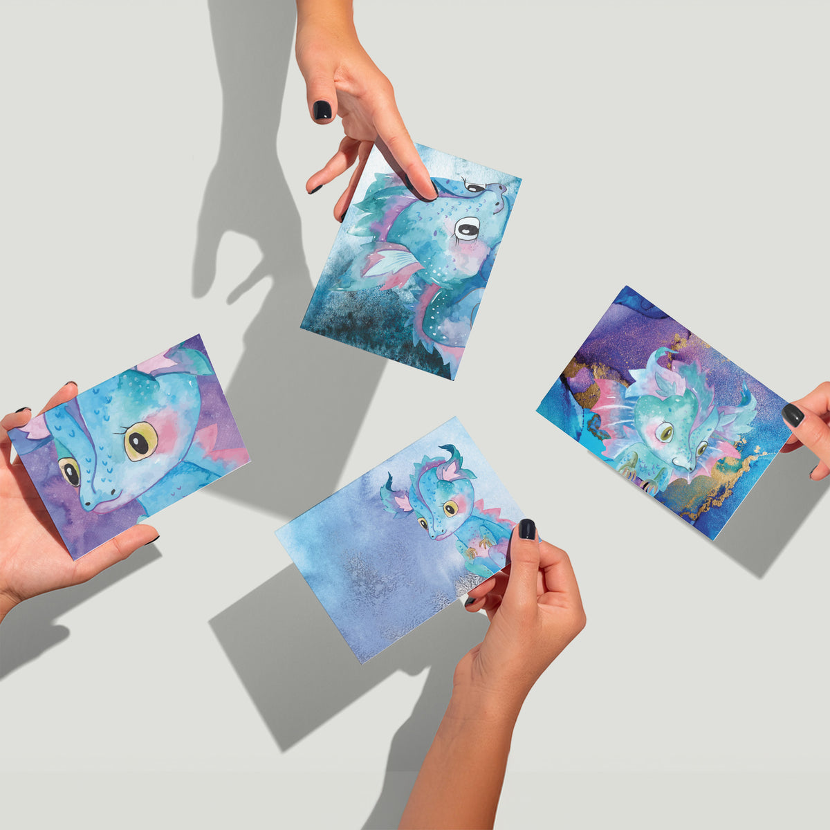 Folded stationery set with fantasy dragon artwork in a watercolor illustration style across assorted colorful designs.