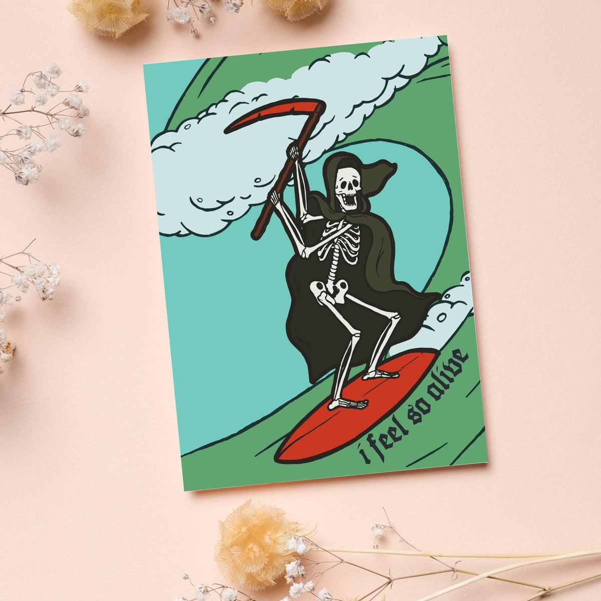Greeting cards with colorful illustrated surfing skeleton and text reading "i feel so alive."