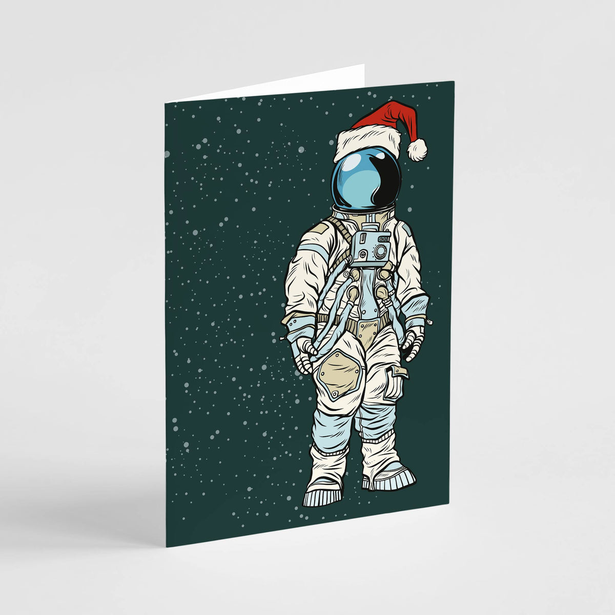 Christmas cards featuring pop art astronaut with red pompom Santa hat on dark teal star-dotted background.