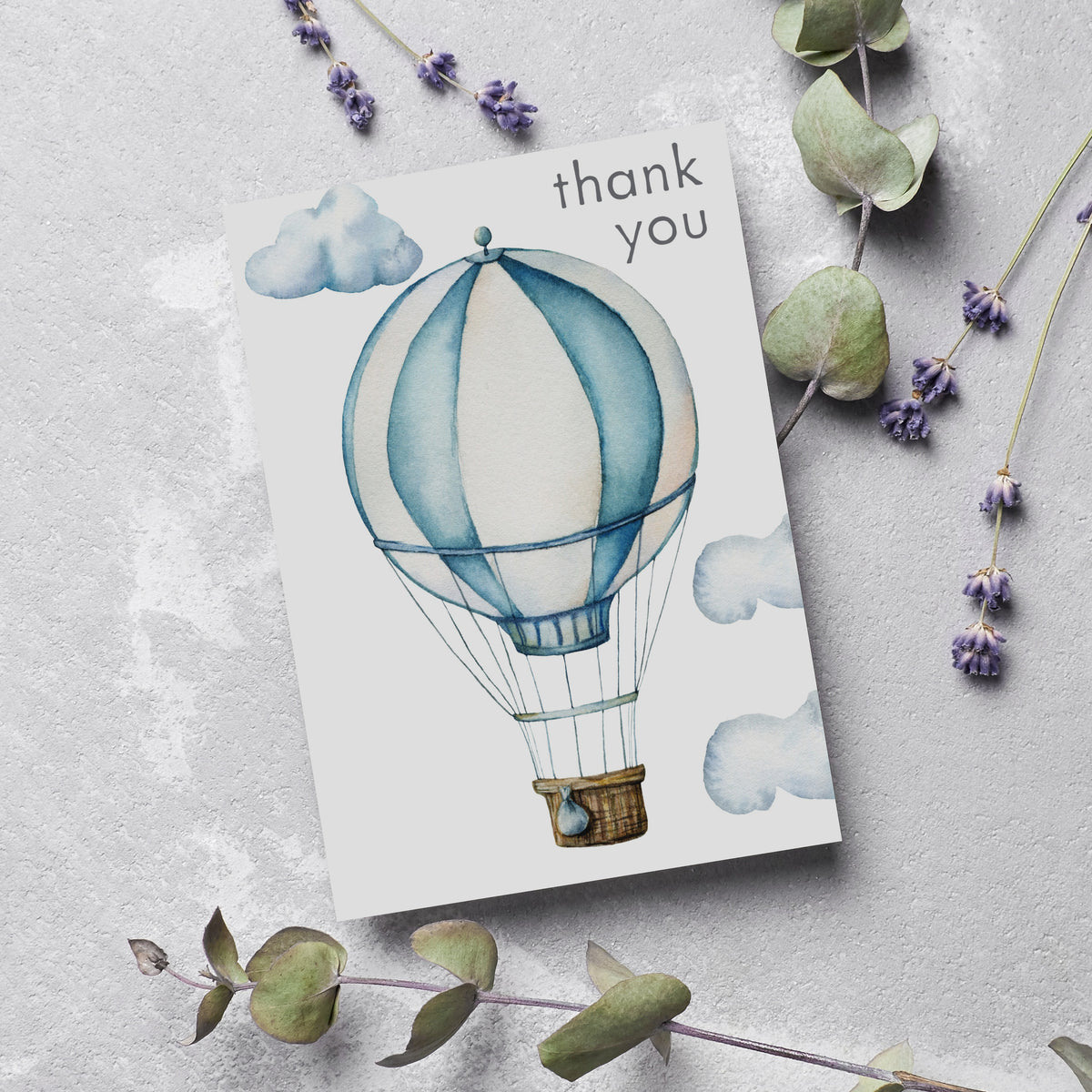 Hot air balloon thank you card, dusty blue and cream palette, soft watercolor clouds, no border, charcoal sans-serif text.