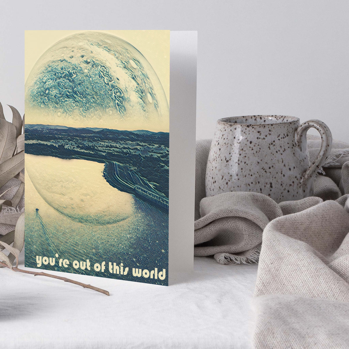 Pack of 24 cards with one design: a muted blue and cream surrealistic scene of a planet above a river landscape.