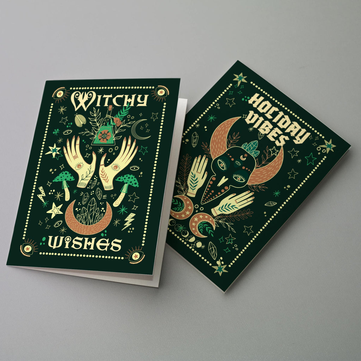 Witchy Christmas cards with cream and sage line art on deep green, six cards each of four illustrated designs.