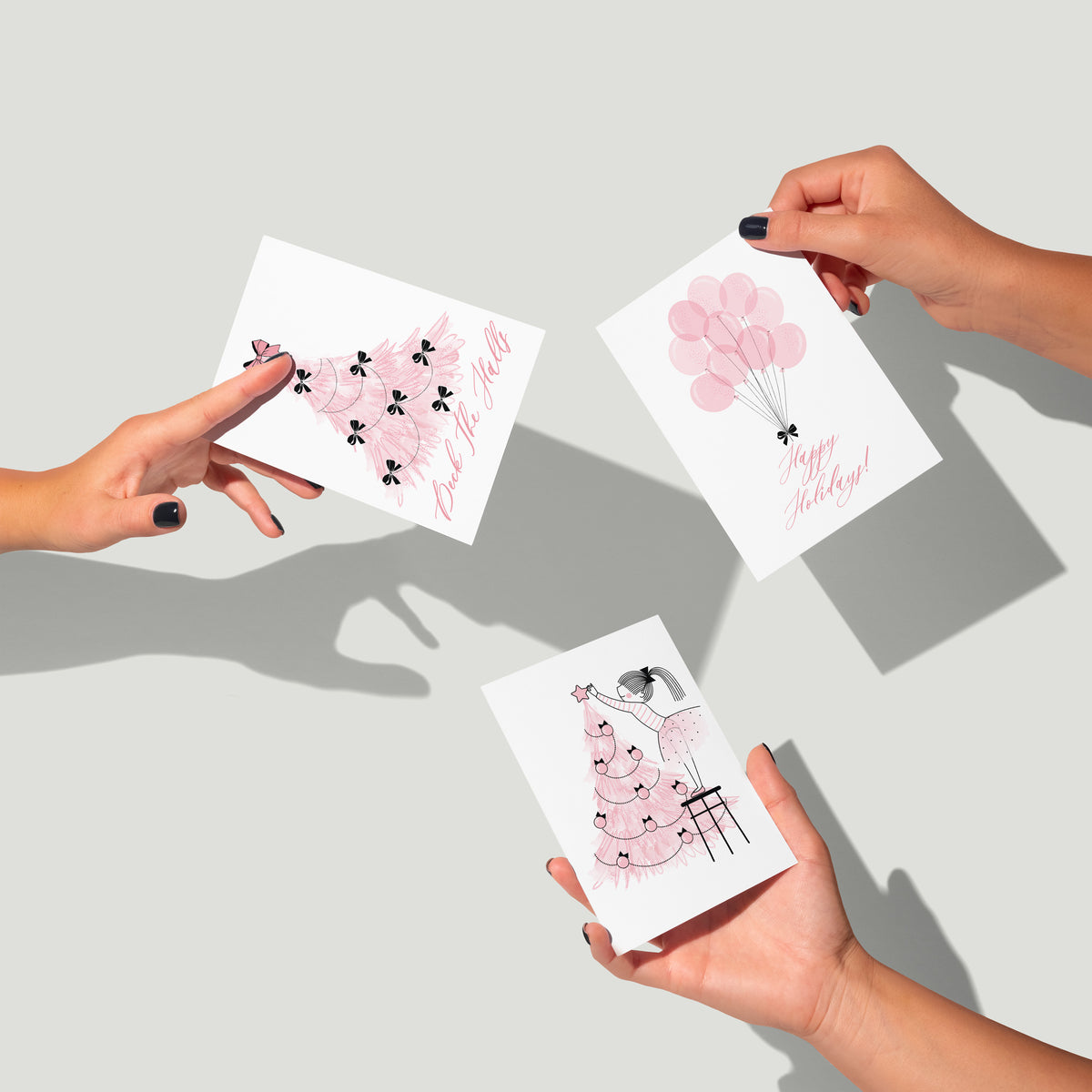 Holiday card collection, 24 cards across eight designs: trees, gifts, balloons, a car, hats, and figures in pink and black.