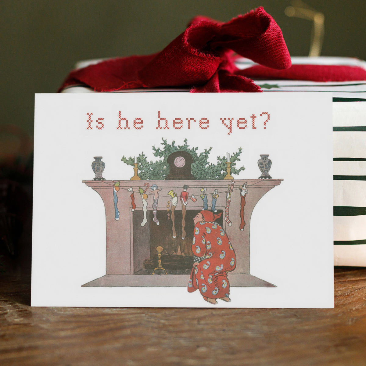 Holiday card set depicting a nightgown-clad child looking up into an arched firebox surrounded by hanging stockings.