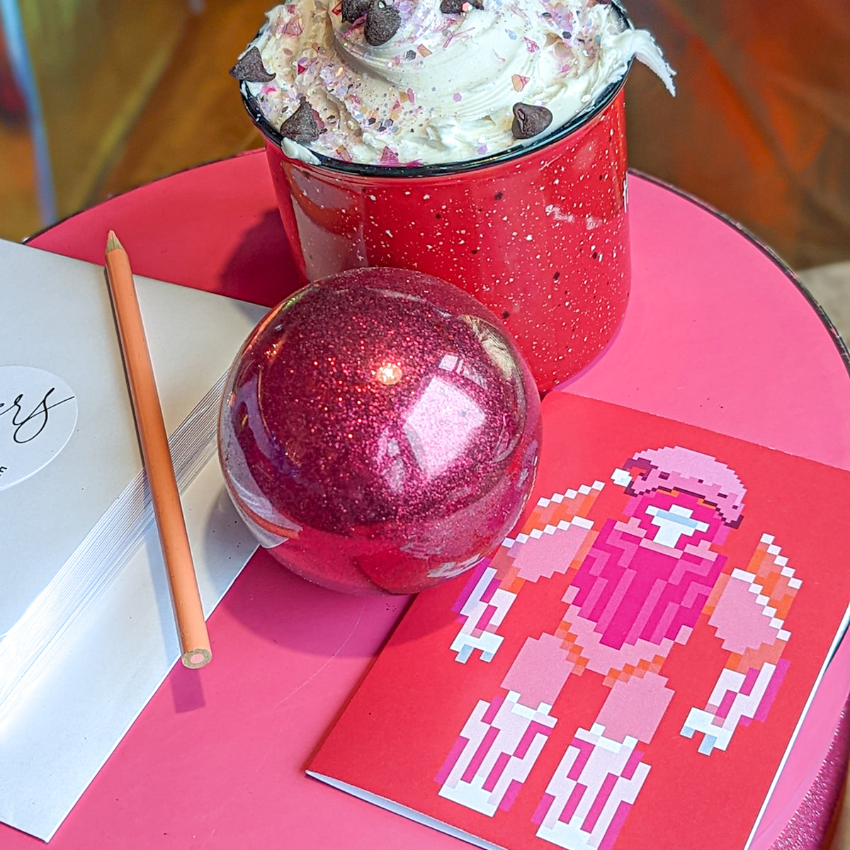 Folded holiday cards with bold graphic designs in pink, red, purple, and black colorways.