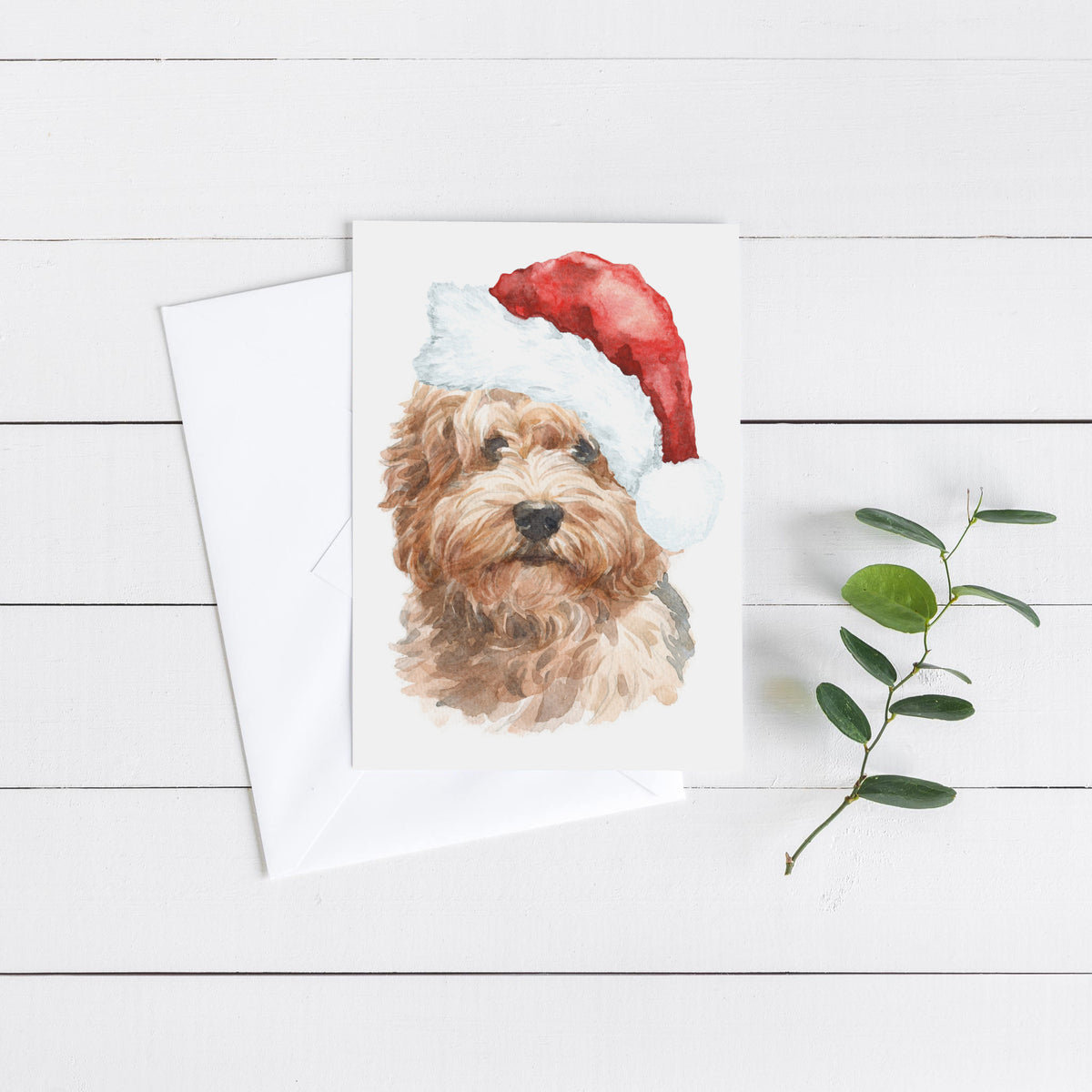 Watercolor labradoodle Christmas card, curly golden fur, red conical hat with white brim and pompom, portrait format.