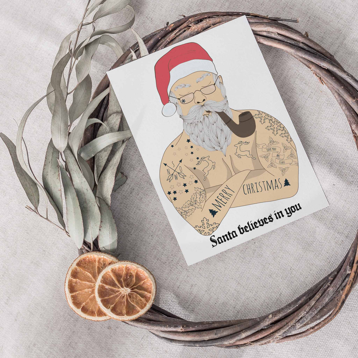 Set of 24 Christmas cards with a bare-chested Santa illustration and the caption Santa believes in you in blackletter type.