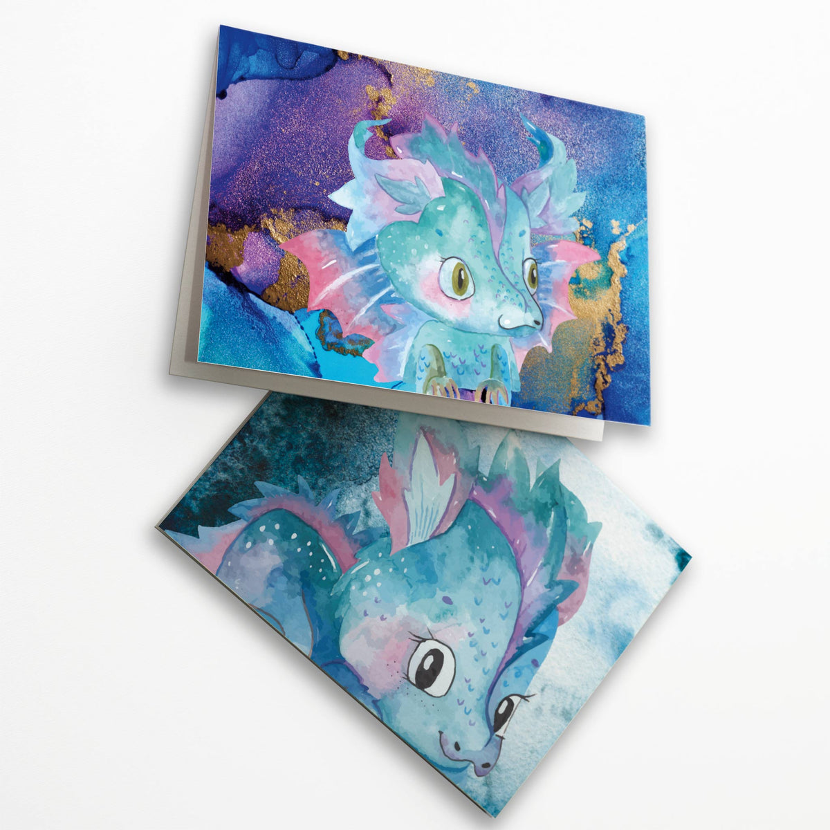 Illustrated dragon notecard collection, 24 folded cards with varied character artwork in blue, purple, teal, and yellow.