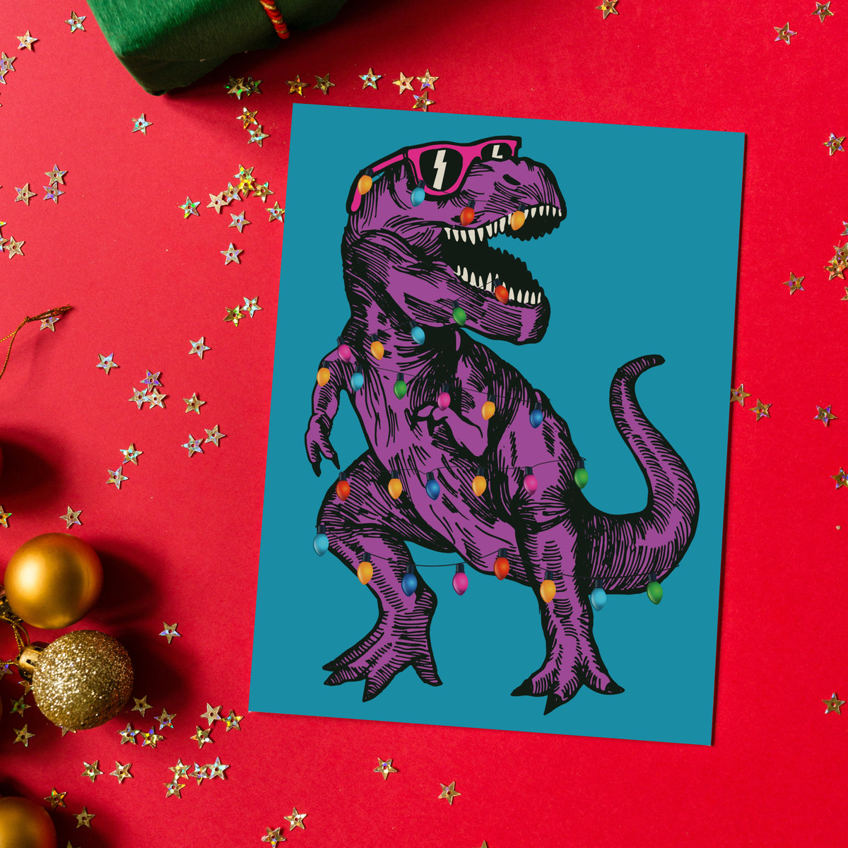 Multicolor-lit dinosaur Christmas cards in purple-on-teal and green-on-red, 24 cards with two designs included.
